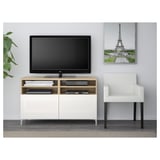 Modern living room with BESTÅ tv stand, flat screen, organized wiring, white armchair, eiffel tower poster.