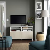 White BESTÅ tv bench with large screen, decor, turquoise chairs, basket, photos, lamp, rug - modern living room.