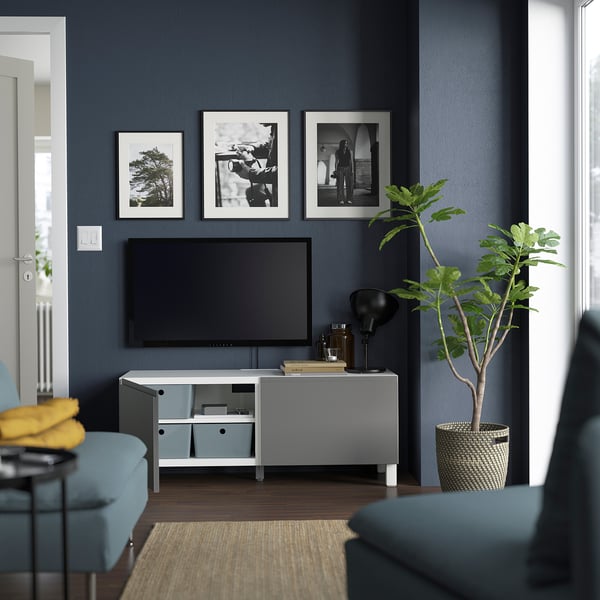 Modern living room with tv on BESTÅ bench, dark blue wall.
