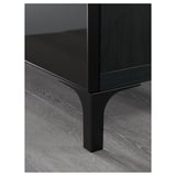 Modern black tv stand detail: sleek glass top, sturdy metal legs, quality finish.