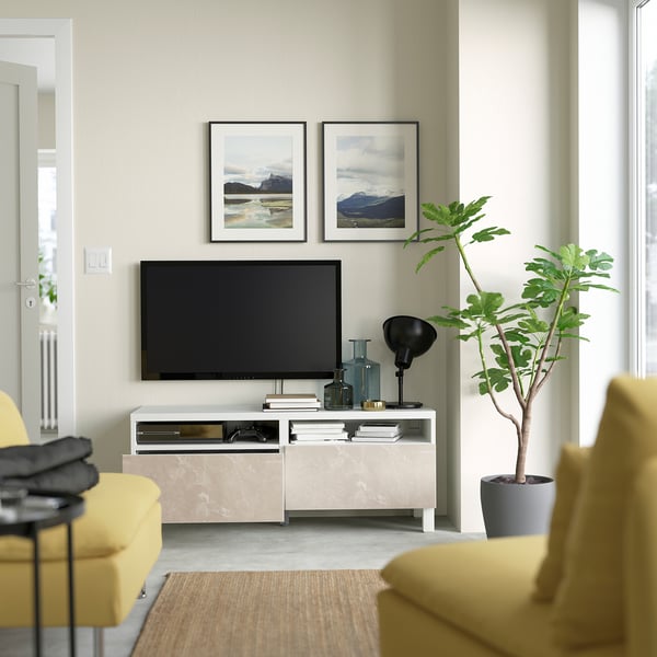 Modern living room with tv, plant, & nature photos.