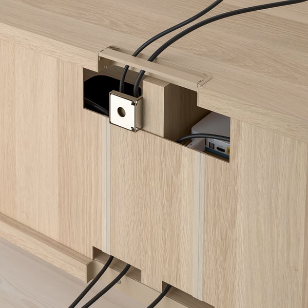 Wooden tv bench with cable outlets and drawers. Cables neatly organized through cutouts, showcasing functional cable management.
