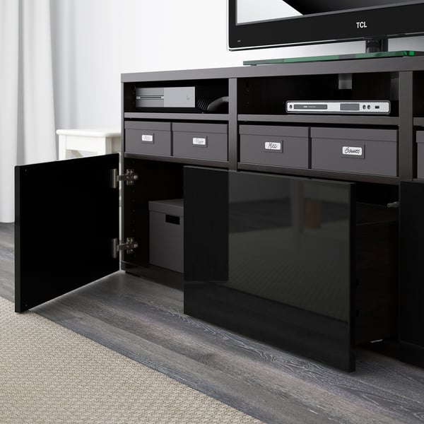 Black tv stand with open doors revealing organized storage. It supports a flat-screen tv on top, featuring adjustable shelves and cable management.