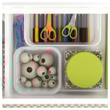 Organized craft drawer with sections: colored pens, scissors, spools of thread, wooden beads, and a bead tray.