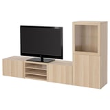 A light oak BESTÅ tv storage unit with a flat-screen tv on top. The unit shelves and drawers for storage and organization.