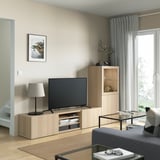 Modern living room with BESTÅ tv storage, flat-screen tv, lamp, tall cabinet, gray rug, dark gray couch.