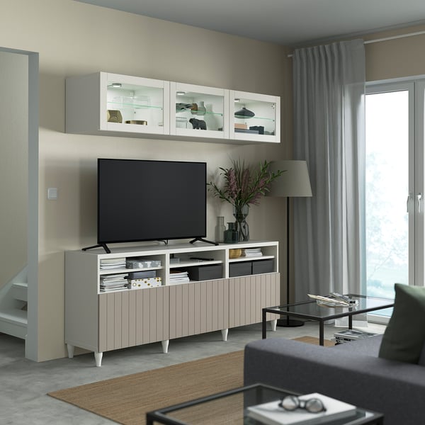 Modern living room with BESTÅ tv unit, flat screen tv, glass cabinets, green sofa, and floor lamp.