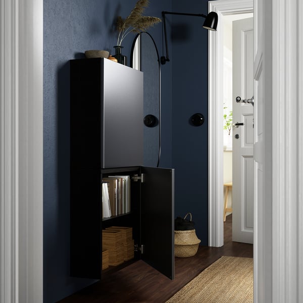 Modern wall cabinet with open door showing organized folders, books, and boxes.
