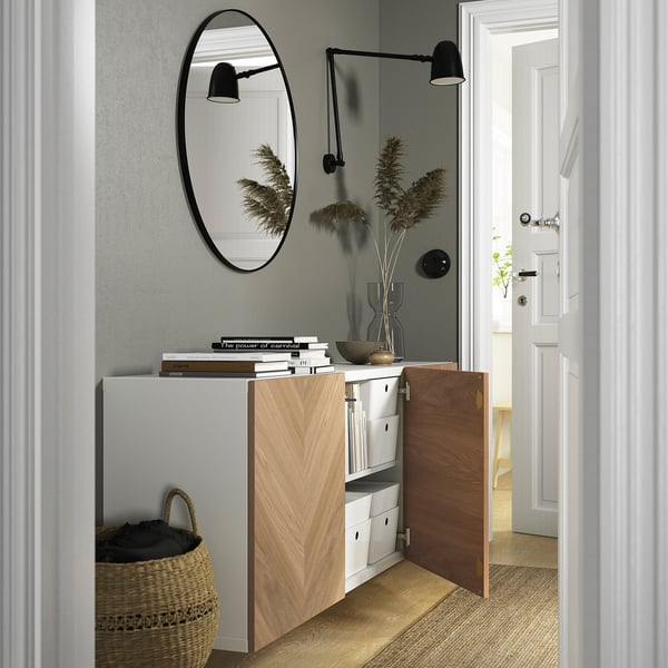 Modern hallway wall-mounted storage with open door, mirror, lights, and decor.