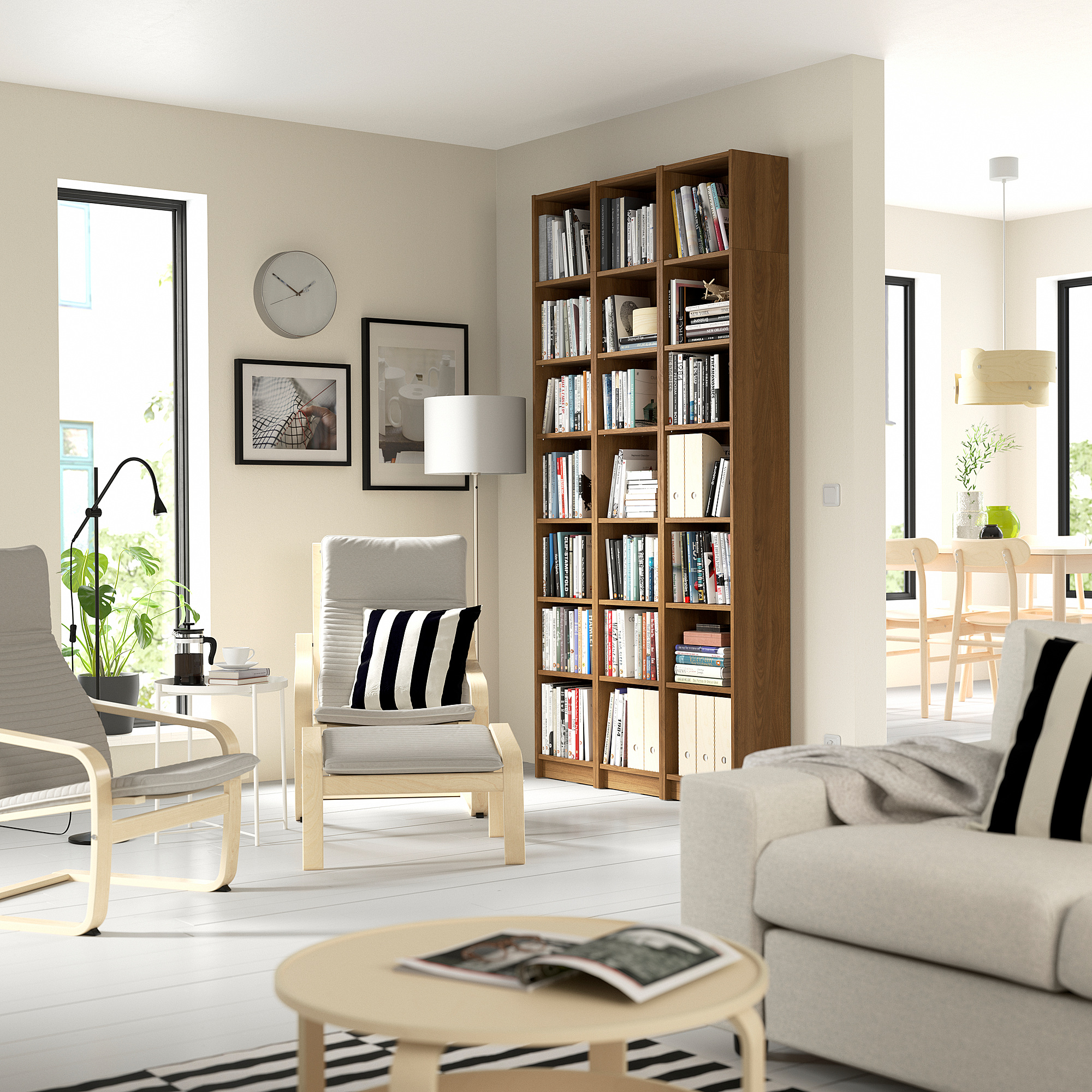 Modern living room with BILLY bookcase, gray sofa, armchairs, and natural light.