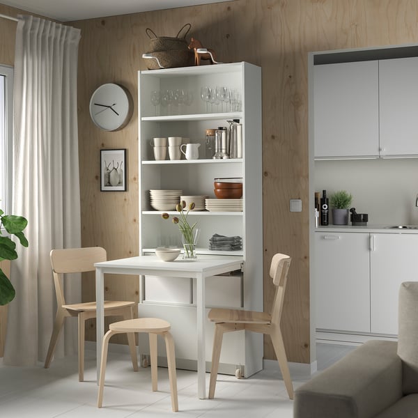 Modern minimalist dining area with white BILLY bookcase-desk combo, light wood chairs, and built-in cabinets.