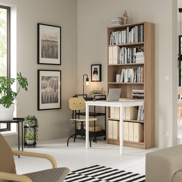 Home office BILLY bookcase with desk in light brown and white, combining storage and workspace efficiently.