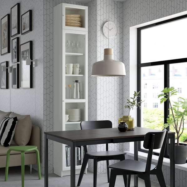 Modern living room with black dining set, green stool, BILLY bookcase, city view.