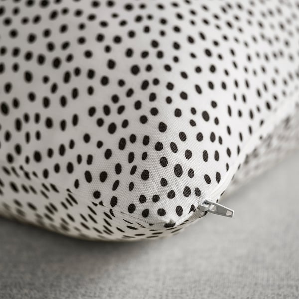 Close-up of soft, high-quality fabric with black dots on white background. Hidden zipper visible at edge.