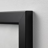 Close-up of a modern black picture frame corner, showing sleek design and quality craftsmanship.