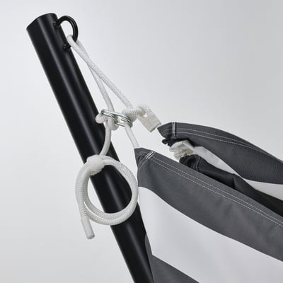 Black hammock stand with white ropes tightly securing a rolled-up gray and white hammock, ready for setup.