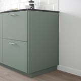 Grey-green recycled kitchen cabinet with metal handles, two drawers.