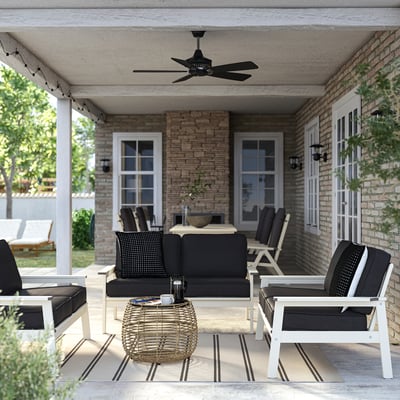 Cozy patio with black BONDHOLMEN 2-seat sofa, striped rug, and ceiling fan.