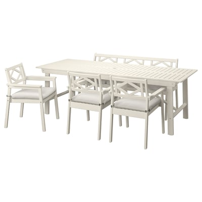 Acacia wood outdoor dining set with table, four chairs, and bench, light grey cushions.