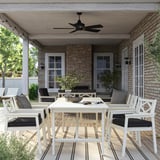 Modern white BONDHOLMEN outdoor dining set. Large acacia table with ceiling fan, eight matching chairs with black cushions, designed for outdoor use.