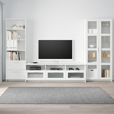 BRIMNES tv unit with shelves and drawers. Centred tv, books, decor. Grey rug, light floor.