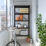 BROR shelves hold up to 95kg, sturdy, and flexible. Black steel, in corner, fits kitchen, bike nearby, durable.