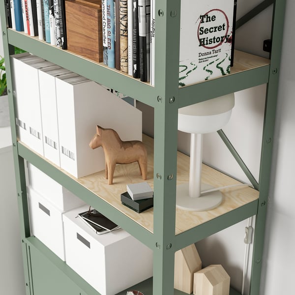 Shelf unit with books, boxes, wooden horse, and lamp. Sturdy, holds heavy items, expandable, durable.