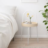 White BURVIK side table with birch top, handle, and flowers.