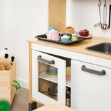 Childrens toy kitchen play set with colorful cups and oven.