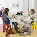 Kids enjoy a tea party with stuffed animals, using a child-sized table and colorful cups and saucers.