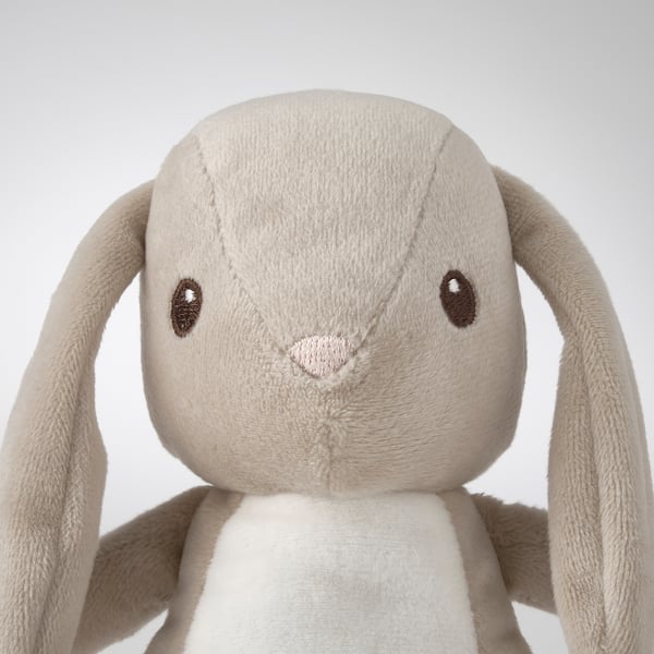 Soft stuffed bunny toy with long ears, embroidered eyes and nose. Neutral beige color.