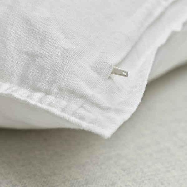 Close-up of white linen cushion cover with hidden zipper, showcasing soft, textured fabric.