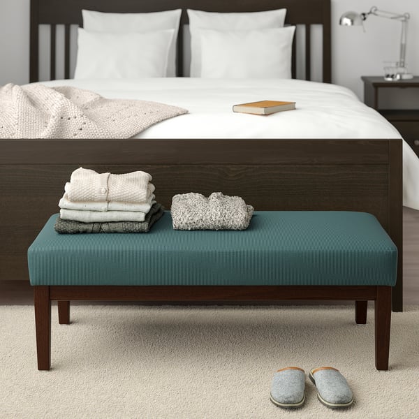 Cozy bedroom: blue EKENÄSET bench with folded towels, slippers, large bed. Bench fits at beds foot.