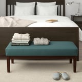 Cozy bedroom: blue EKENÄSET bench with folded towels, slippers, large bed. Bench fits at beds foot.