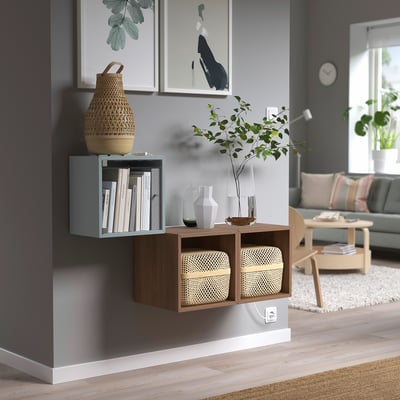 EKET grey-blue bookcase with glass and wood, holding books and decor. Smaller than the sofa and larger than vases.