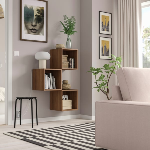 Modern living room with EKET wooden wall shelf, books, and decorations.