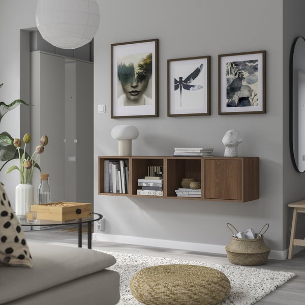 Wall-mounted shelves with art, books, light furniture, grey rug, sofa.