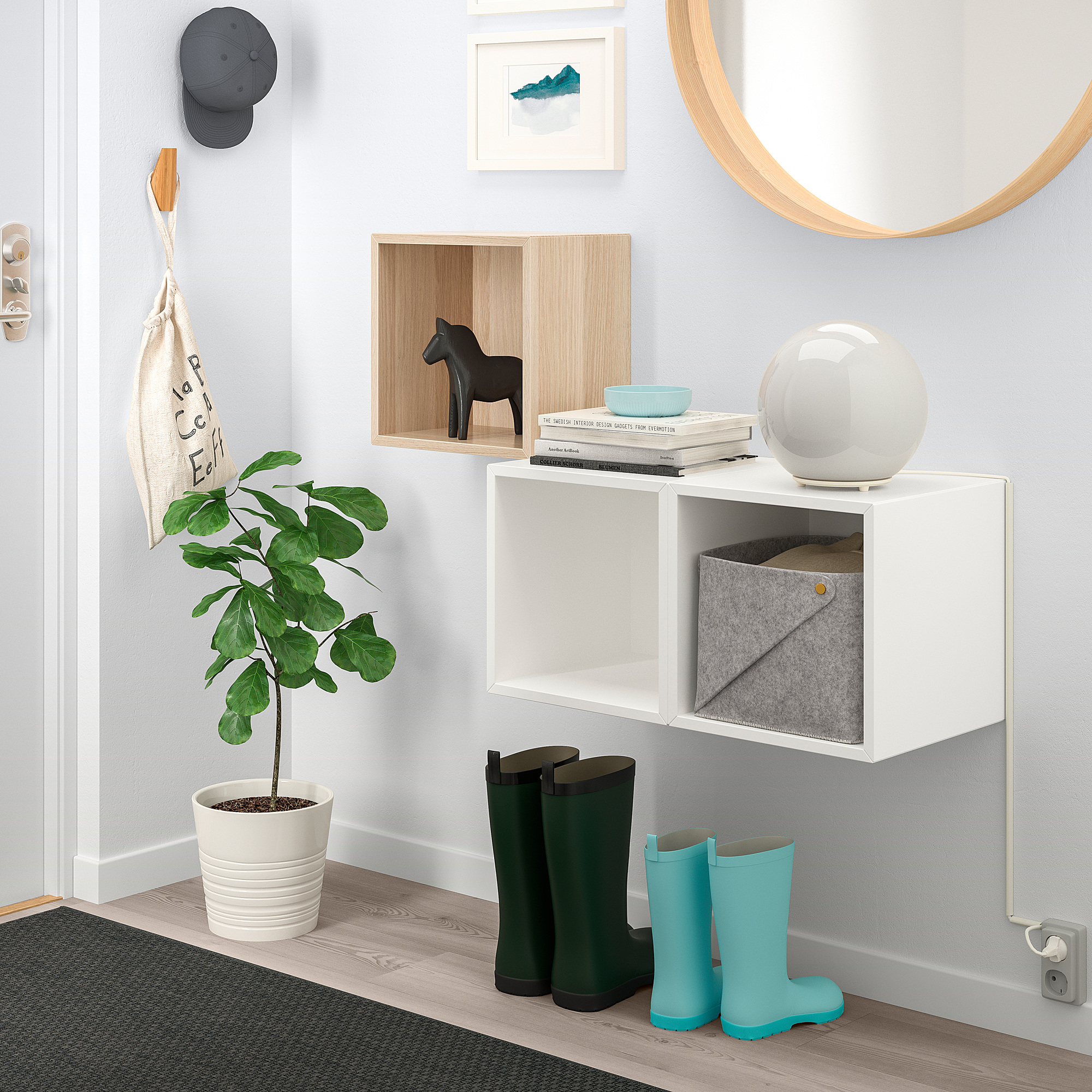 Wall-mounted EKET cabinets with mirror, plants, and boots.