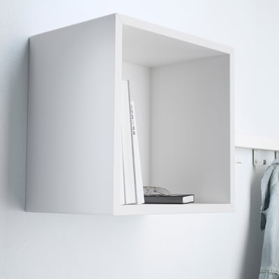 A wall-mounted cube shelf, part of the EKET system, stores books and holds items on its shelf.