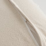 Close-up of cushion cover with zipper, soft cotton, white geometric pattern.