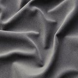 Grey soft fabric close-up, textured weave visible, folds and shadows highlight depth.