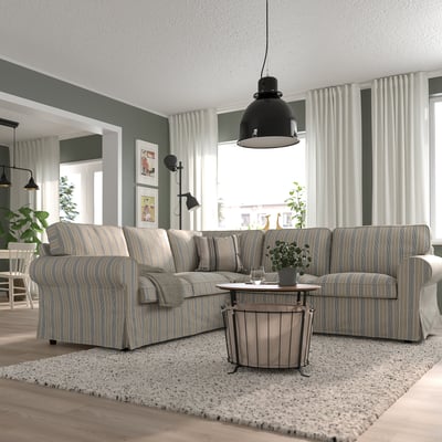 L-shaped EKTORP sofa in grey, under black pendant light, with wooden table and plants. Stylish, spacious living area.