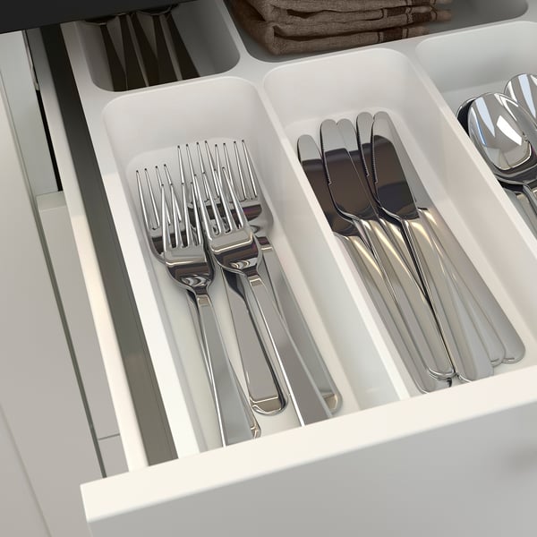 Silverware organizer in kitchen drawer, with compartments for forks, knives, and spoons.