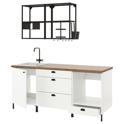 Modern white kitchen setup with wooden top, black accents, open shelves, and sink.