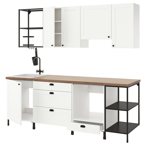Modern white kitchen setup with wooden countertop, black accents, and open storage; sleek and functional design.