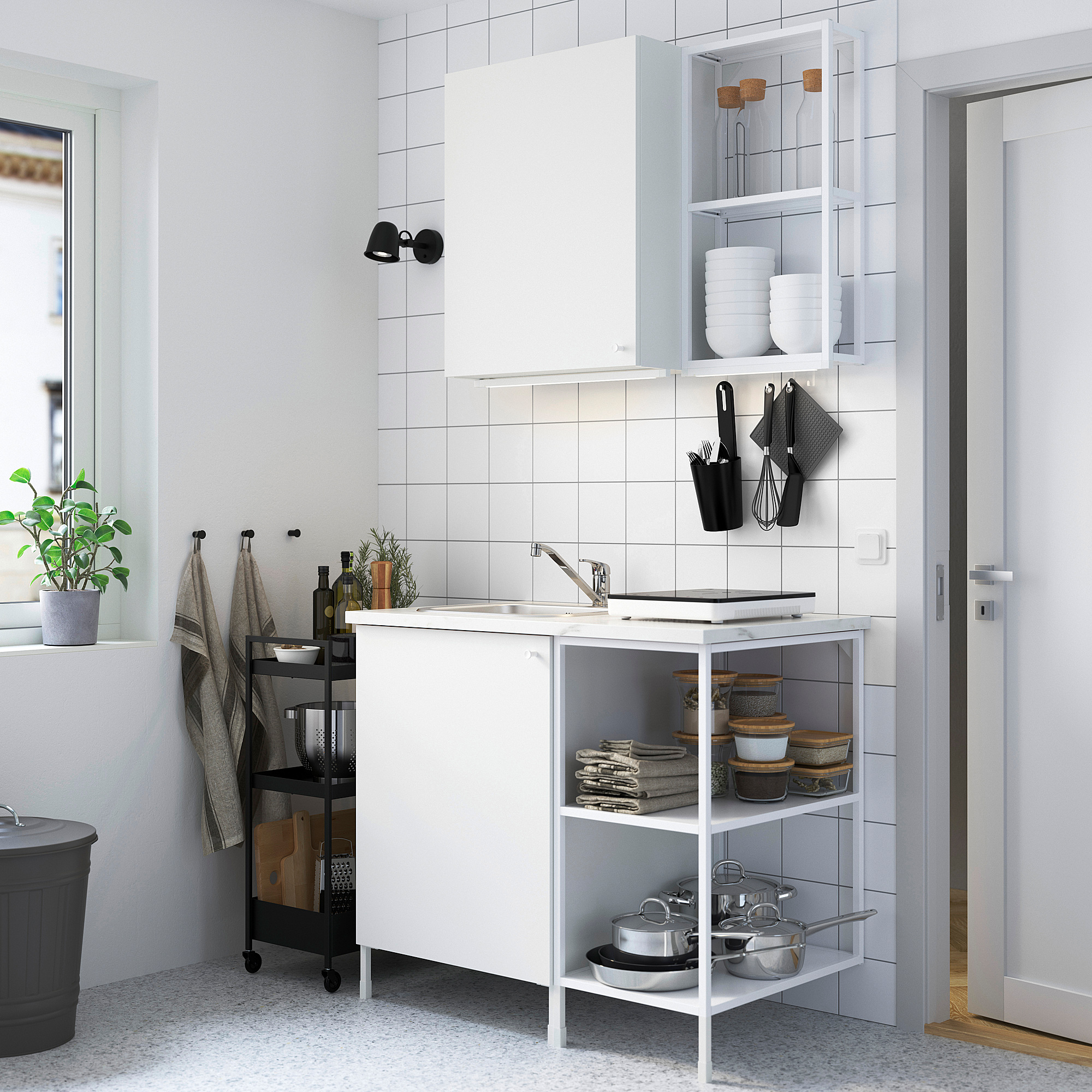 White kitchen with marble counters, stainless sink, and mixed storage. Door leads to another room.