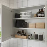Open bathroom cabinet with mirrors, storing bottles, bags, and toiletries on shelves.