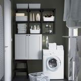 White ENHET storage with laundry items, washing machine, stool, and basket.
