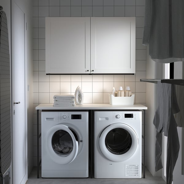 Compact laundry setup: ENHET units, washing machine, dryer, iron, supplies