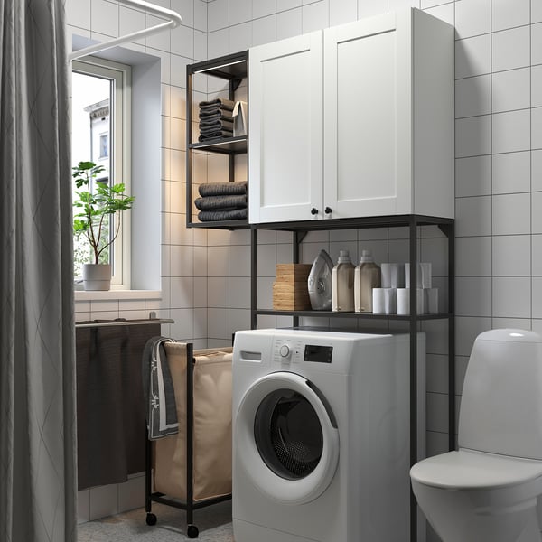 White ENHET laundry cabinet and shelves for washing machine, iron, detergents, and towels.